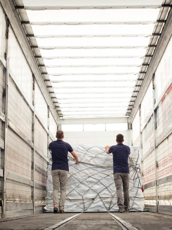 Workers pushing freight in air freight container